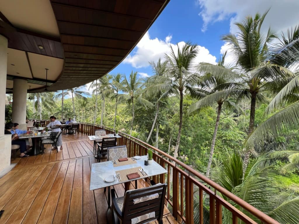 Open terrace restaurant with views of palm trees and the Ayung River in Sayan, Bali